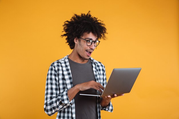 Retrato de un joven africano excitado en anteojos