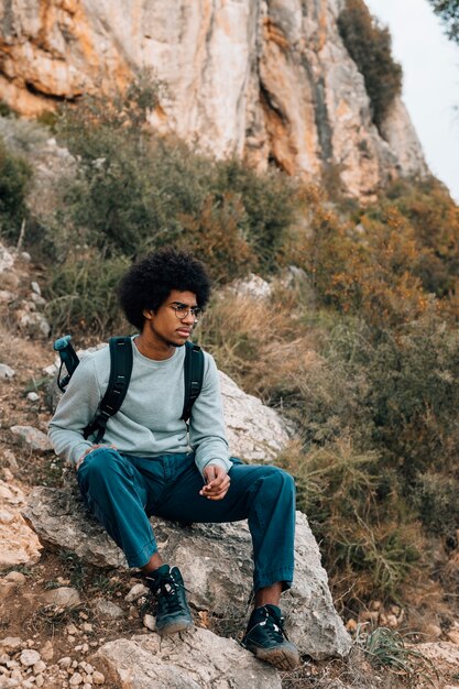 Retrato de joven africano sentado en la montaña