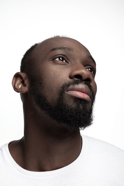 Retrato de un joven africano serio en el estudio. Modelo masculino de alta moda posando y aislado sobre fondo blanco.