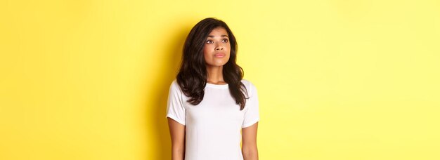 Retrato de una joven afroamericana esperanzada que anhela algo mirando a la esquina superior izquierda dr.