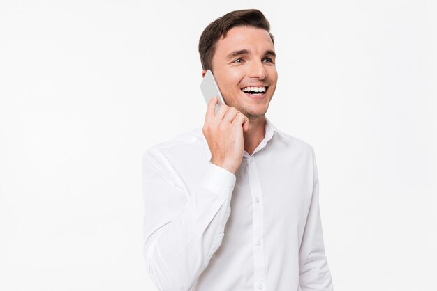 Retrato de un joven alegre en una camisa blanca hablando