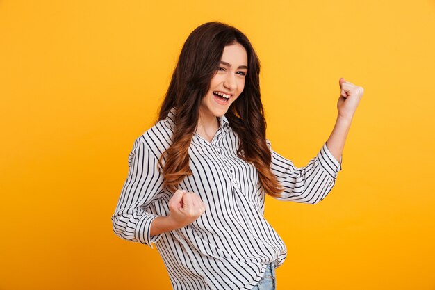 Retrato de una joven alegre celebrando el éxito