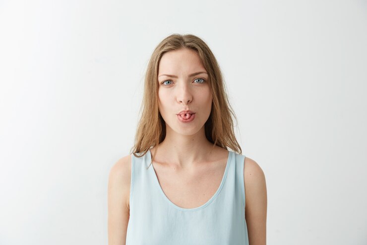 Foto gratuito retrato de joven alegre divertida que muestra la lengua.