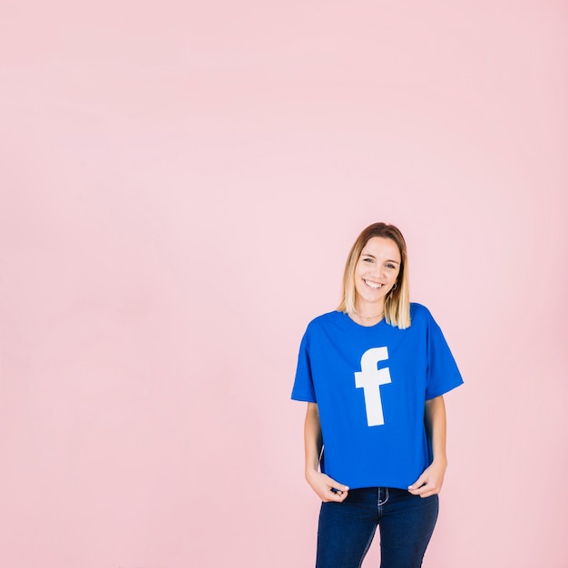 Retrato de un joven amigo sonriente con camiseta azul de facebook