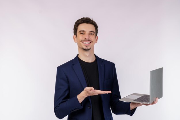 Retrato de un joven apuesto hombre de negocios sonriente sosteniendo una laptop en las manos escribiendo y navegando por páginas web aisladas de fondo blanco