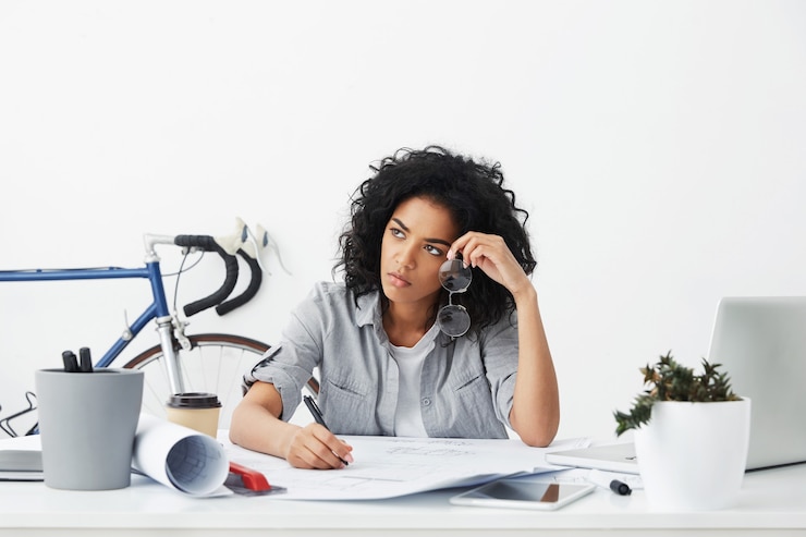 Foto gratuito retrato de joven arquitecta afroamericana infeliz y cansado trabajando en planos