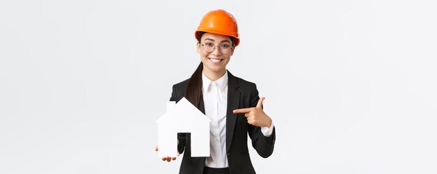 Retrato de una joven arquitecta ingeniera de construcción asiática en casco de seguridad y traje de negocios po