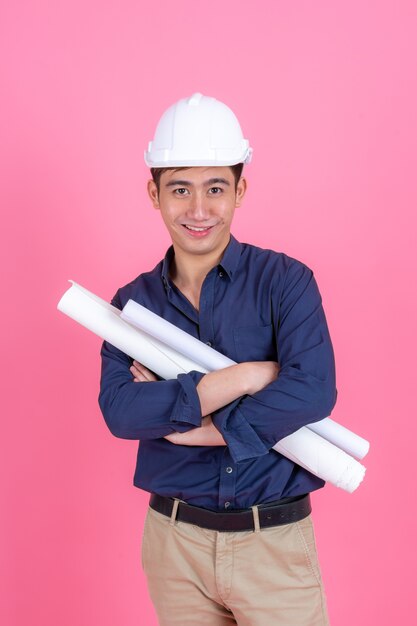 Retrato joven arquitecto hombre con casco y mantenga impresión azul