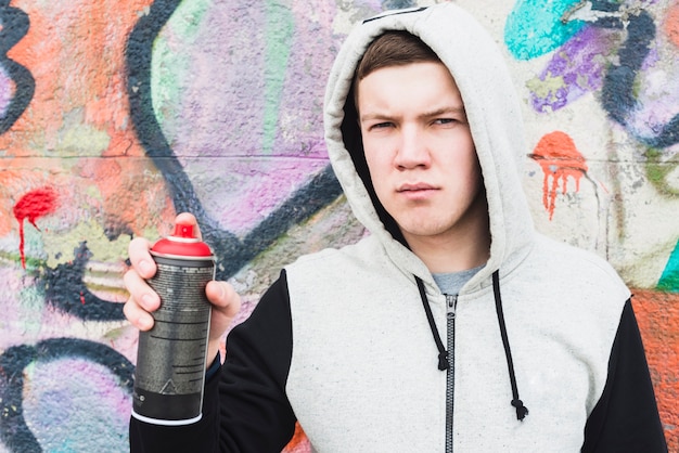 Foto gratuita retrato de un joven artista con botella de spray