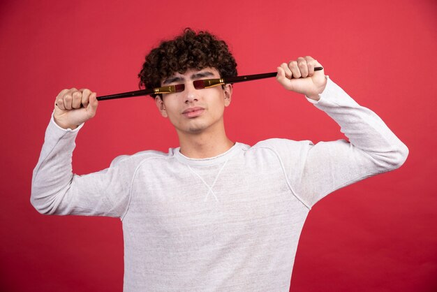 Retrato de un joven artista masculino cerrando los ojos con pinceles.