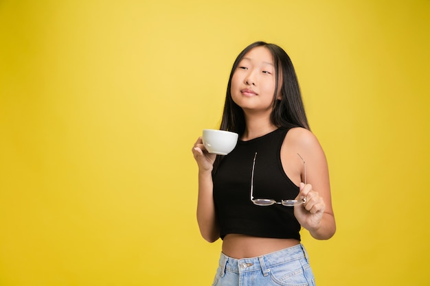Retrato de joven asiática aislada en amarillo