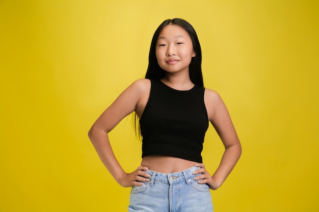 Retrato de joven asiática aislada en estudio amarillo