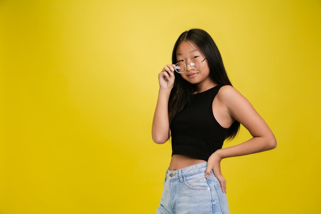 Retrato de joven asiática aislada en estudio amarillo
