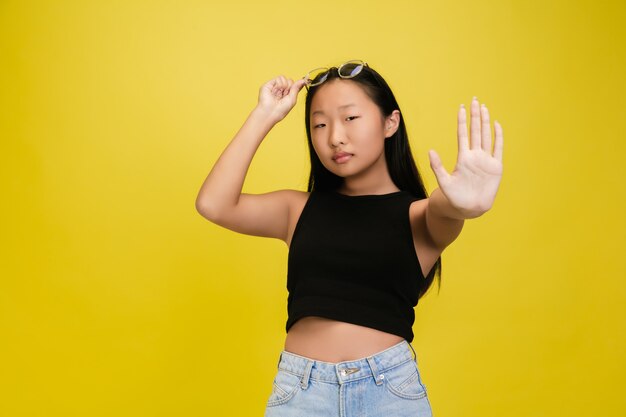 Retrato de joven asiática aislada en estudio amarillo