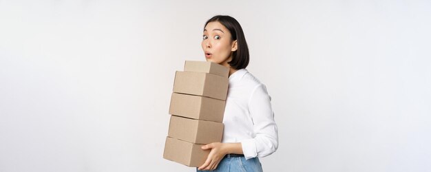 Retrato de una joven asiática sosteniendo cajas que transportan productos de entrega empresaria coreana reunida