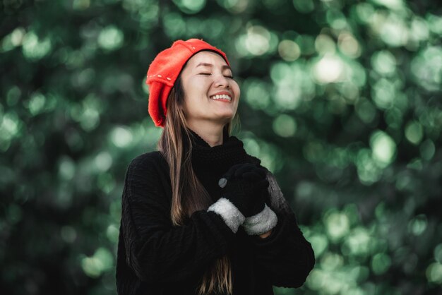 Retrato de una joven asiática vestida de invierno rezando por la mañana en el bosque Cristianismo y fe esperanza concepto de amor