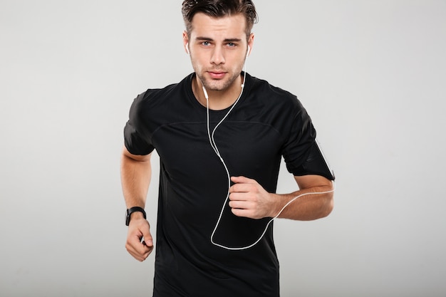Retrato de un joven atleta motivado en auriculares
