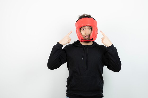 Retrato de joven atlético en pie de sombrero de boxeo rojo.