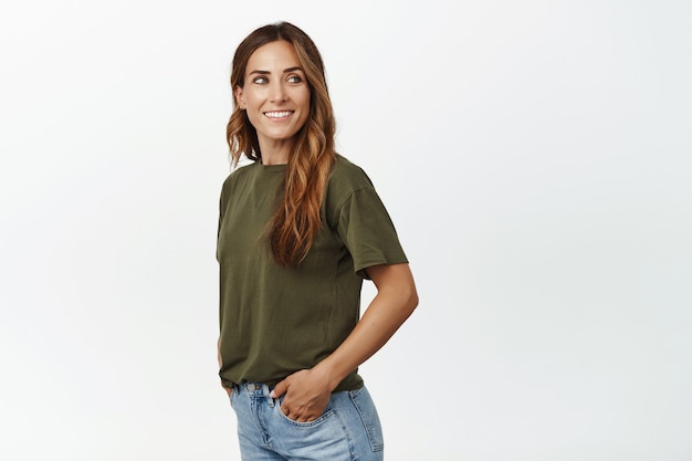 Retrato de joven atractiva mujer de mediana edad sonriendo, mirando detrás de su hombro