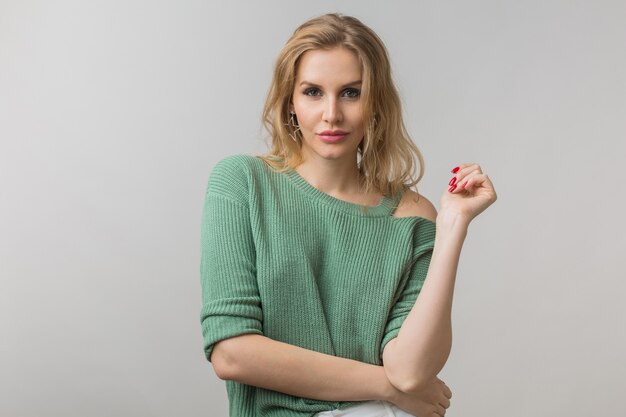 Retrato de joven atractiva mujer sexy segura, estilo casual, suéter verde, independiente, modelo posando sobre fondo blanco de estudio, aislado, mirando a puerta cerrada, coqueta