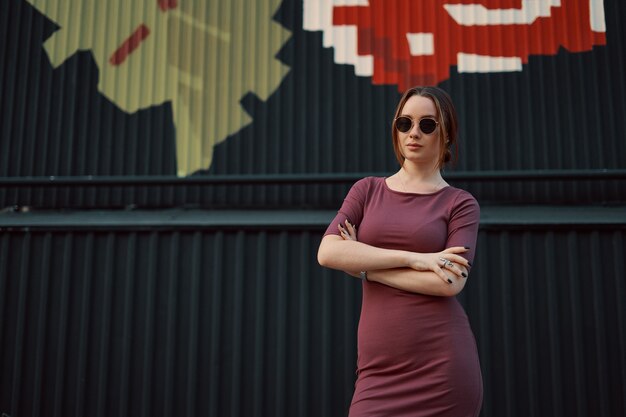 Foto gratuita retrato de joven atractiva posando contra la pared oscura