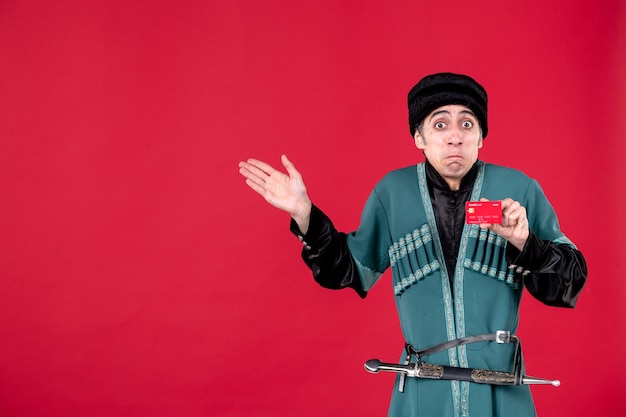 Foto gratuita retrato de joven azeri en traje tradicional con tarjeta de crédito en rojo