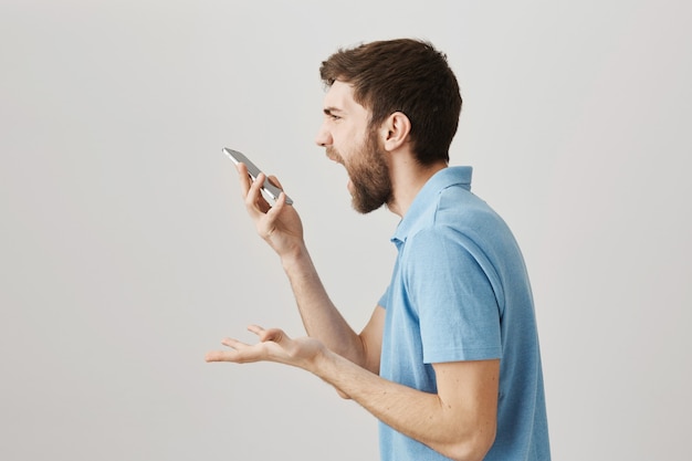 Retrato de un joven barbudo con camiseta azul