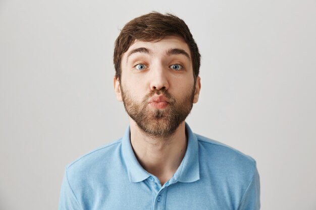 Retrato de un joven barbudo con camiseta azul