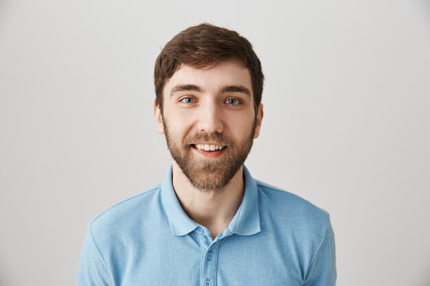 Retrato de un joven barbudo con camiseta azul