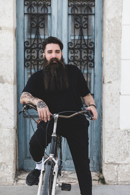 Retrato de un joven barbudo con su bicicleta