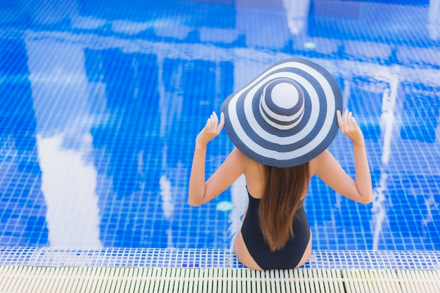 Retrato de joven y bella mujer asiática relajándose alrededor de la piscina al aire libre en el hotel resort