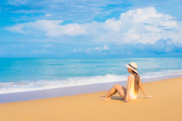 Retrato de joven y bella mujer asiática relajante en la playa en vacaciones de viaje