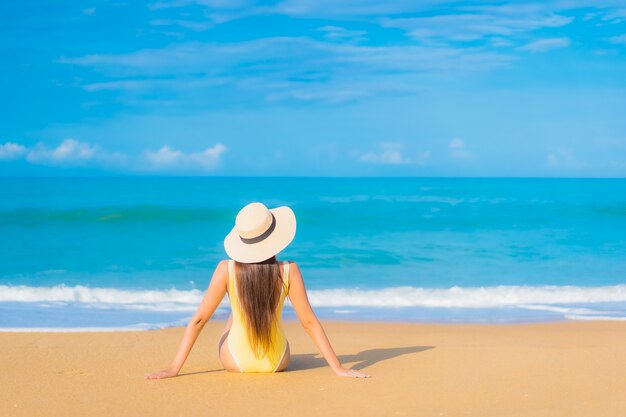 Retrato de joven y bella mujer asiática relajante en la playa en vacaciones de viaje