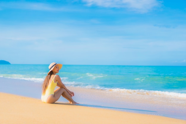 Retrato de joven y bella mujer asiática relajante en la playa en vacaciones de viaje