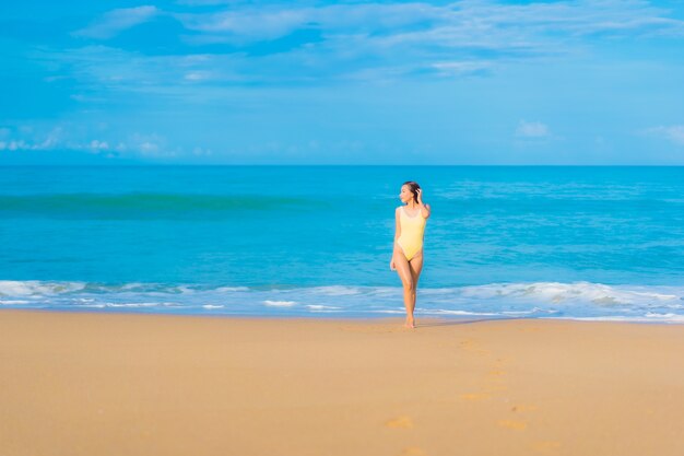 Retrato de joven y bella mujer asiática relajante en la playa en vacaciones de viaje