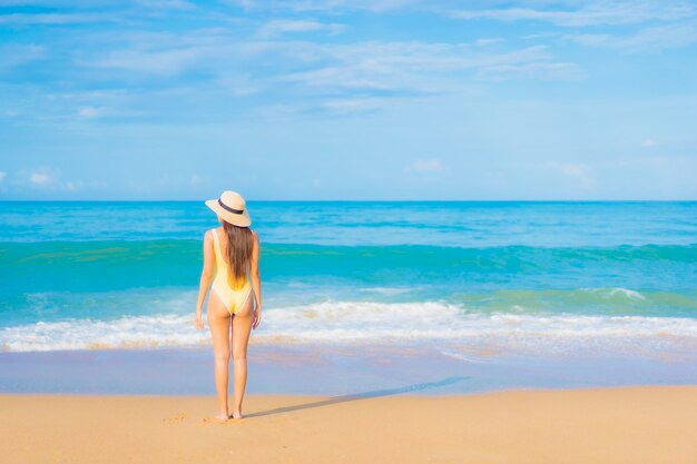 Retrato de joven y bella mujer asiática relajante en la playa en vacaciones de viaje