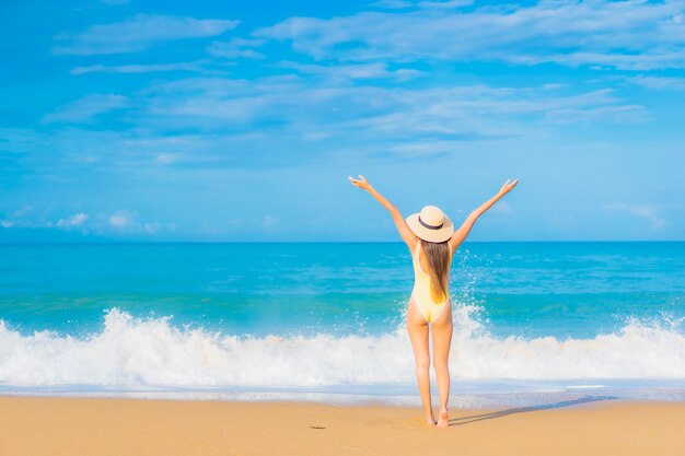 Retrato de joven y bella mujer asiática relajante en la playa en vacaciones de viaje