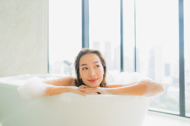 Retrato joven y bella mujer asiática relajarse y descansar en la bañera