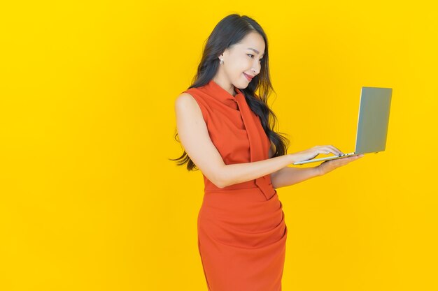 Retrato joven y bella mujer asiática sonrisa con ordenador portátil sobre fondo aislado