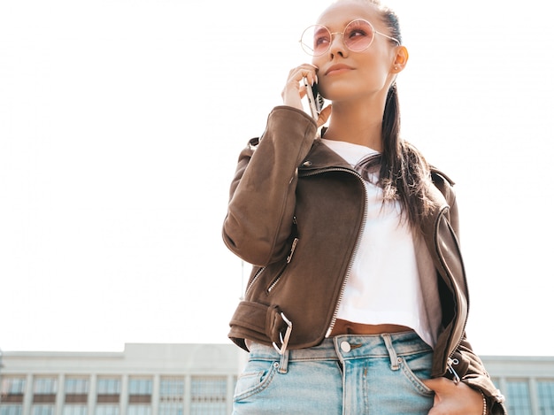 Retrato de joven bella mujer hablando por teléfono Chica de moda en ropa casual de verano Mujer seria posando en la calle