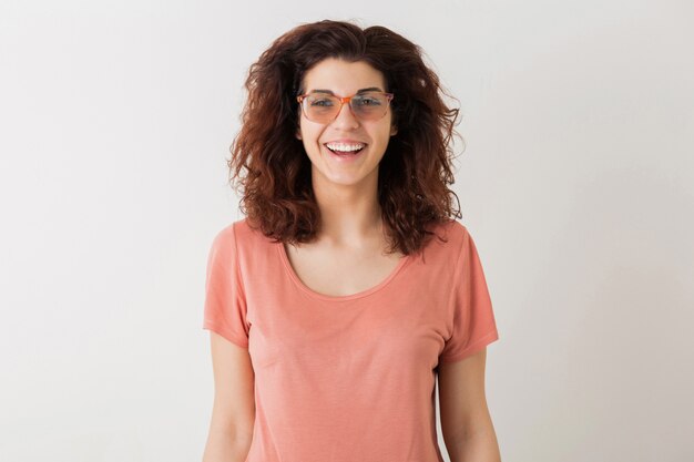 Retrato de joven bella mujer hipster feliz natural con peinado rizado en camisa rosa posando con gafas aislado, estado de ánimo positivo