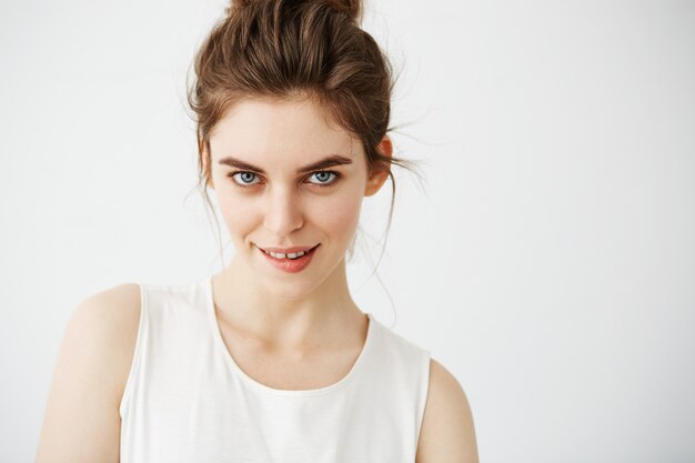 Retrato de joven bella mujer juguetona con bollo mordiendo labio posando.