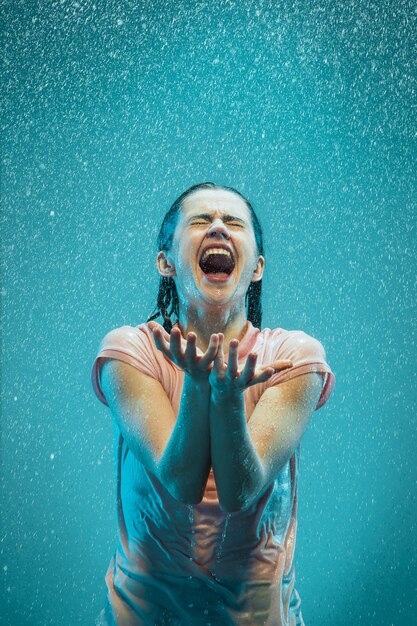 Retrato de joven bella mujer bajo la lluvia