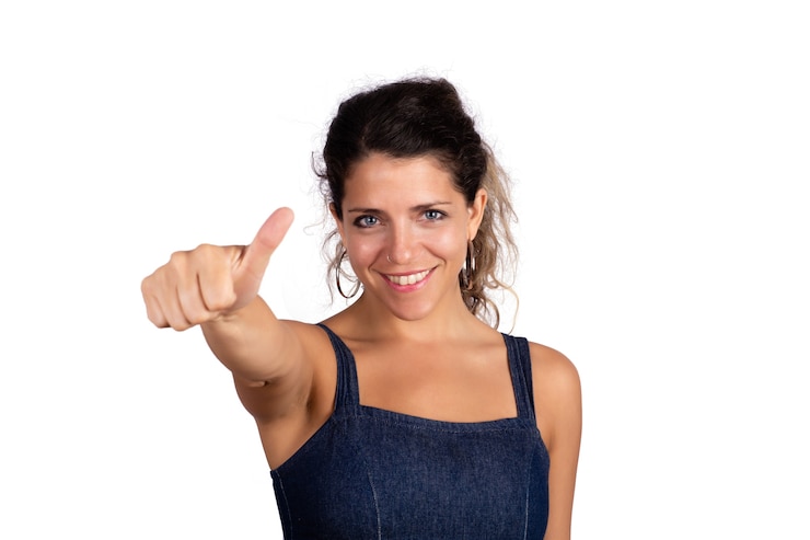Foto gratuito retrato de joven bella mujer con pulgares arriba en estudio. fondo blanco aislado.