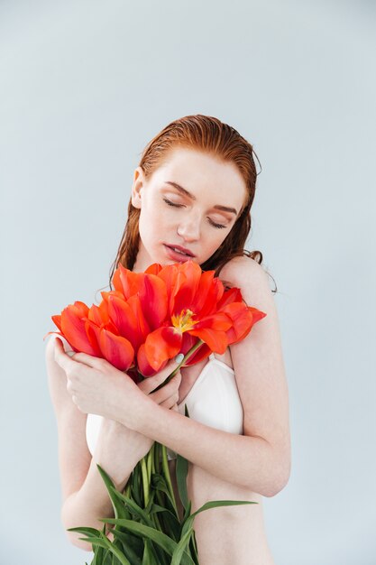 Retrato de una joven bella mujer con ramo de tulipanes