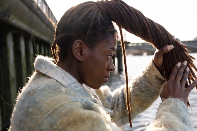 Retrato de joven bella mujer con rastas afro en la ciudad