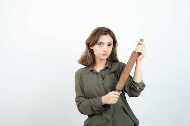 Retrato de joven bella mujer con rodillo de madera de pie. foto de alta calidad