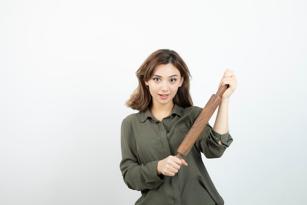 Retrato de joven bella mujer con rodillo de madera de pie. foto de alta calidad