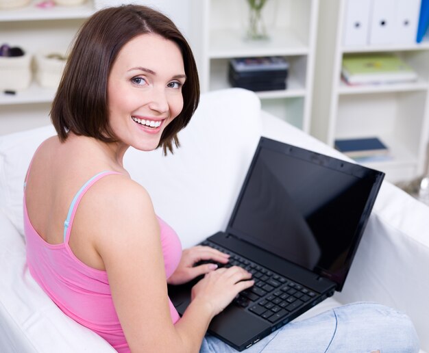 Retrato de joven bella mujer sonriente con portátil - en interiores