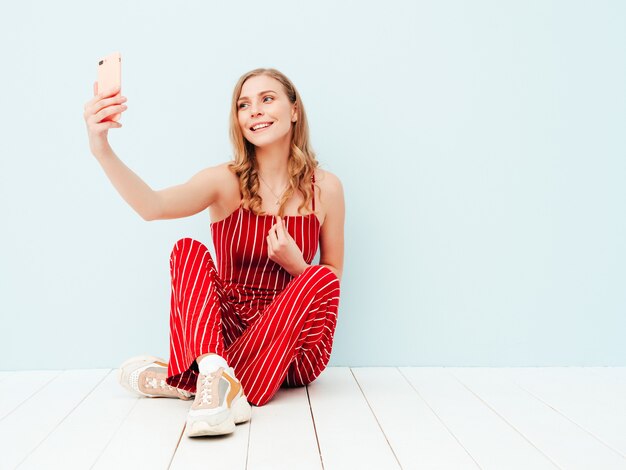 Retrato de joven bella mujer sonriente en ropa de traje rojo de verano de moda